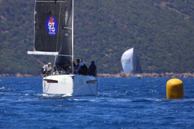 Bodrum, Hindi. 27 Nisan 2024: Ege Denizi 'nin mavi sularında, ünlü tatil beldesi Bodrum' un kıyılarında yelkenliler rüzgarlı havada yelken açıyor.