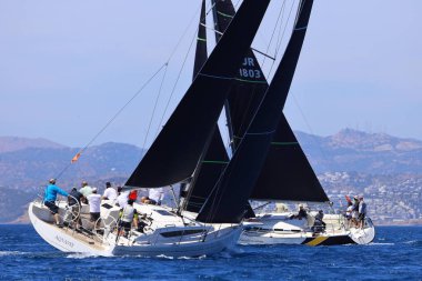 Bodrum, Hindi. 27 Nisan 2024: Ege Denizi 'nin mavi sularında, ünlü tatil beldesi Bodrum' un kıyılarında yelkenliler rüzgarlı havada yelken açıyor.