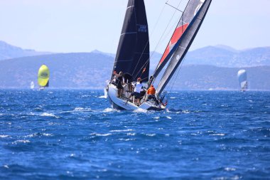 Bodrum, Hindi. 27 Nisan 2024: Ege Denizi 'nin mavi sularında, ünlü tatil beldesi Bodrum' un kıyılarında yelkenliler rüzgarlı havada yelken açıyor.