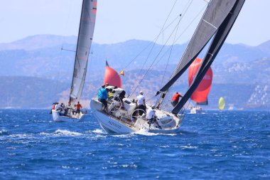 Bodrum, Hindi. 27 Nisan 2024: Ege Denizi 'nin mavi sularında, ünlü tatil beldesi Bodrum' un kıyılarında yelkenliler rüzgarlı havada yelken açıyor.