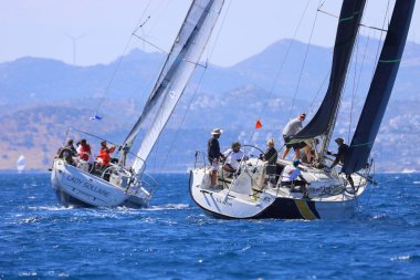 Bodrum, Hindi. 27 Nisan 2024: Ege Denizi 'nin mavi sularında, ünlü tatil beldesi Bodrum' un kıyılarında yelkenliler rüzgarlı havada yelken açıyor.