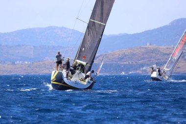 Bodrum, Hindi. 27 Nisan 2024: Ege Denizi 'nin mavi sularında, ünlü tatil beldesi Bodrum' un kıyılarında yelkenliler rüzgarlı havada yelken açıyor.