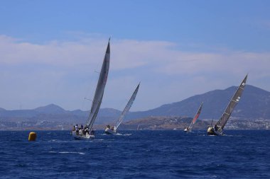 Bodrum, Hindi. 27 Nisan 2024: Ege Denizi 'nin mavi sularında, ünlü tatil beldesi Bodrum' un kıyılarında yelkenliler rüzgarlı havada yelken açıyor.