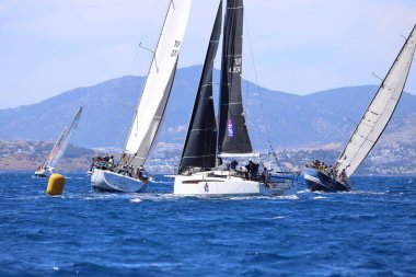 Bodrum, Hindi. 27 Nisan 2024: Ege Denizi 'nin mavi sularında, ünlü tatil beldesi Bodrum' un kıyılarında yelkenliler rüzgarlı havada yelken açıyor.