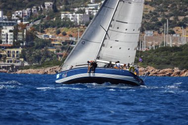 Bodrum, Hindi. 27 Nisan 2024: Ege Denizi 'nin mavi sularında, ünlü tatil beldesi Bodrum' un kıyılarında yelkenliler rüzgarlı havada yelken açıyor.