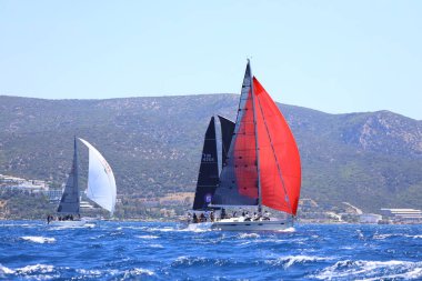 Bodrum, Hindi. 25 Mayıs 2024: Yelkenliler Ege Denizi 'nin mavi sularında, ünlü tatil beldesi Bodrum' un kıyılarında rüzgarlı havada yelken açıyor..