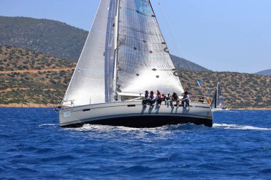 Bodrum, Hindi. 25 Mayıs 2024: Yelkenliler Ege Denizi 'nin mavi sularında, ünlü tatil beldesi Bodrum' un kıyılarında rüzgarlı havada yelken açıyor..