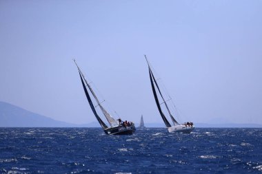 Bodrum, Hindi. 25 Mayıs 2024: Yelkenliler Ege Denizi 'nin mavi sularında, ünlü tatil beldesi Bodrum' un kıyılarında rüzgarlı havada yelken açıyor..