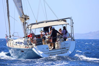 Bodrum, Hindi. 25 Mayıs 2024: Yelkenliler Ege Denizi 'nin mavi sularında, ünlü tatil beldesi Bodrum' un kıyılarında rüzgarlı havada yelken açıyor..