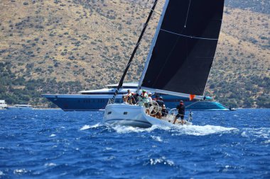 Bodrum, Hindi. 25 Mayıs 2024: Yelkenliler Ege Denizi 'nin mavi sularında, ünlü tatil beldesi Bodrum' un kıyılarında rüzgarlı havada yelken açıyor..