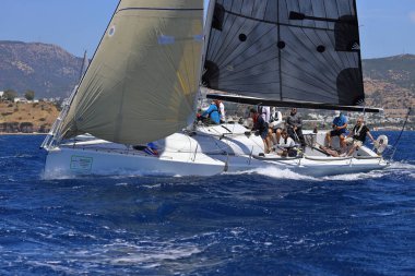 Bodrum, Hindi. 25 Mayıs 2024: Yelkenliler Ege Denizi 'nin mavi sularında, ünlü tatil beldesi Bodrum' un kıyılarında rüzgarlı havada yelken açıyor..