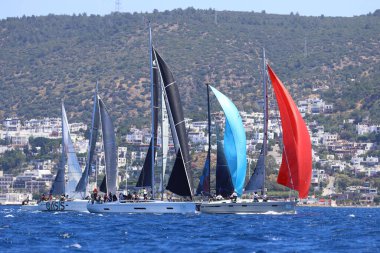 Bodrum, Hindi. 25 Mayıs 2024: Yelkenliler Ege Denizi 'nin mavi sularında, ünlü tatil beldesi Bodrum' un kıyılarında rüzgarlı havada yelken açıyor..