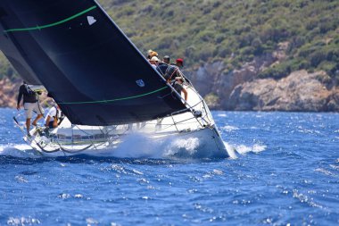 Bodrum, Hindi. 25 Mayıs 2024: Yelkenliler Ege Denizi 'nin mavi sularında, ünlü tatil beldesi Bodrum' un kıyılarında rüzgarlı havada yelken açıyor..