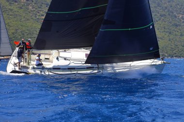 Bodrum, Hindi. 25 Mayıs 2024: Yelkenliler Ege Denizi 'nin mavi sularında, ünlü tatil beldesi Bodrum' un kıyılarında rüzgarlı havada yelken açıyor..