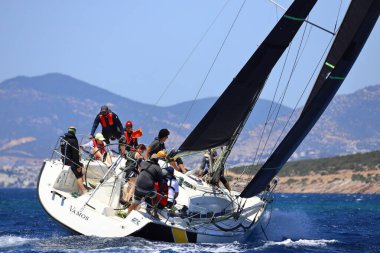 Bodrum, Hindi. 25 Mayıs 2024: Yelkenliler Ege Denizi 'nin mavi sularında, ünlü tatil beldesi Bodrum' un kıyılarında rüzgarlı havada yelken açıyor..