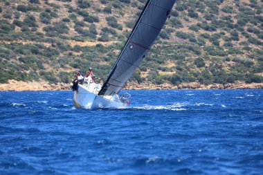 Bodrum, Hindi. 25 Mayıs 2024: Yelkenliler Ege Denizi 'nin mavi sularında, ünlü tatil beldesi Bodrum' un kıyılarında rüzgarlı havada yelken açıyor..