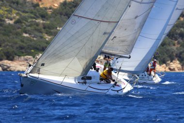 Bodrum, Hindi. 25 Mayıs 2024: Yelkenliler Ege Denizi 'nin mavi sularında, ünlü tatil beldesi Bodrum' un kıyılarında rüzgarlı havada yelken açıyor..