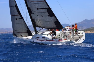 Bodrum, Hindi. 25 Mayıs 2024: Yelkenliler Ege Denizi 'nin mavi sularında, ünlü tatil beldesi Bodrum' un kıyılarında rüzgarlı havada yelken açıyor..