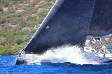 Bodrum, Hindi. 25 Mayıs 2024: Yelkenliler Ege Denizi 'nin mavi sularında, ünlü tatil beldesi Bodrum' un kıyılarında rüzgarlı havada yelken açıyor..