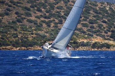 Bodrum, Hindi. 25 Mayıs 2024: Yelkenliler Ege Denizi 'nin mavi sularında, ünlü tatil beldesi Bodrum' un kıyılarında rüzgarlı havada yelken açıyor..