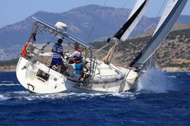 Bodrum, Hindi. 25 Mayıs 2024: Yelkenliler Ege Denizi 'nin mavi sularında, ünlü tatil beldesi Bodrum' un kıyılarında rüzgarlı havada yelken açıyor..