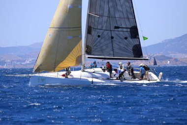 Bodrum, Hindi. 25 Mayıs 2024: Yelkenliler Ege Denizi 'nin mavi sularında, ünlü tatil beldesi Bodrum' un kıyılarında rüzgarlı havada yelken açıyor..