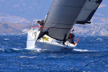 Bodrum, Hindi. 25 Mayıs 2024: Yelkenliler Ege Denizi 'nin mavi sularında, ünlü tatil beldesi Bodrum' un kıyılarında rüzgarlı havada yelken açıyor..