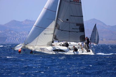 Bodrum, Hindi. 25 Mayıs 2024: Yelkenliler Ege Denizi 'nin mavi sularında, ünlü tatil beldesi Bodrum' un kıyılarında rüzgarlı havada yelken açıyor..