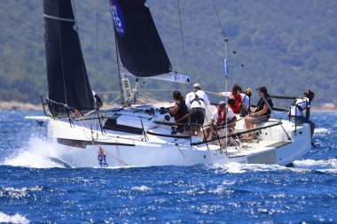 Bodrum, Hindi. 25 Mayıs 2024: Yelkenliler Ege Denizi 'nin mavi sularında, ünlü tatil beldesi Bodrum' un kıyılarında rüzgarlı havada yelken açıyor..