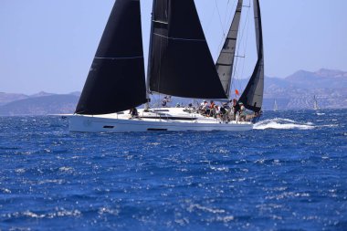 Bodrum, Hindi. 25 Mayıs 2024: Yelkenliler Ege Denizi 'nin mavi sularında, ünlü tatil beldesi Bodrum' un kıyılarında rüzgarlı havada yelken açıyor..