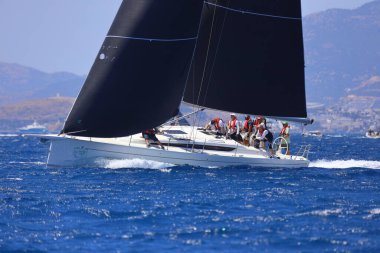 Bodrum, Hindi. 25 Mayıs 2024: Yelkenliler Ege Denizi 'nin mavi sularında, ünlü tatil beldesi Bodrum' un kıyılarında rüzgarlı havada yelken açıyor..