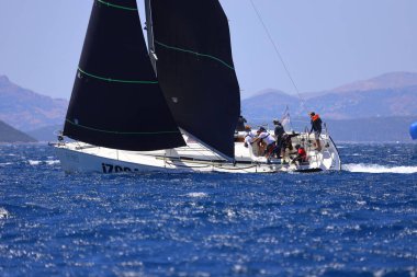 Bodrum, Hindi. 25 Mayıs 2024: Yelkenliler Ege Denizi 'nin mavi sularında, ünlü tatil beldesi Bodrum' un kıyılarında rüzgarlı havada yelken açıyor..