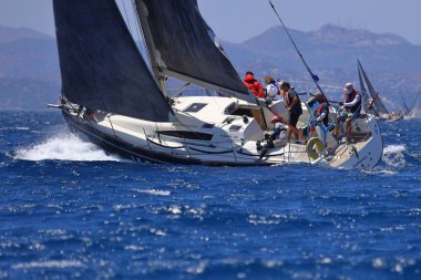 Bodrum, Hindi. 25 Mayıs 2024: Yelkenliler Ege Denizi 'nin mavi sularında, ünlü tatil beldesi Bodrum' un kıyılarında rüzgarlı havada yelken açıyor..