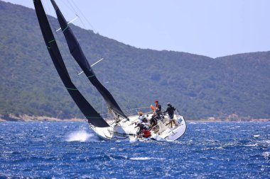 Bodrum, Hindi. 25 Mayıs 2024: Yelkenliler Ege Denizi 'nin mavi sularında, ünlü tatil beldesi Bodrum' un kıyılarında rüzgarlı havada yelken açıyor..