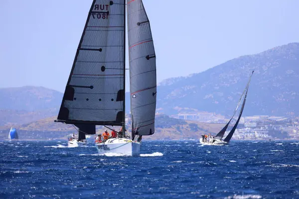 Bodrum, Hindi. 25 Mayıs 2024: Yelkenliler Ege Denizi 'nin mavi sularında, ünlü tatil beldesi Bodrum' un kıyılarında rüzgarlı havada yelken açıyor..