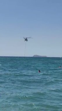 İtfaiye helikopteri denizden su alıyor. sosyal medya için dikey video.