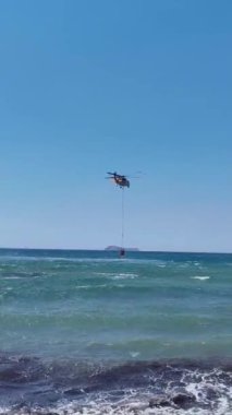 İtfaiye helikopteri denizden su alıyor. sosyal medya için dikey video.