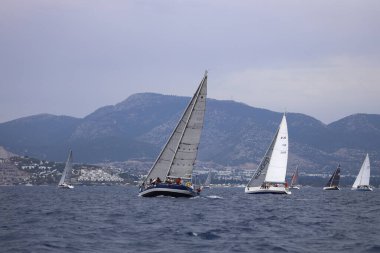 Bodrum, Hindi. 26 Mayıs 2024: Yelkenliler Ege Denizi 'nin mavi sularında, ünlü tatil beldesi Bodrum' un kıyılarında rüzgarlı havada yelken açıyorlar..