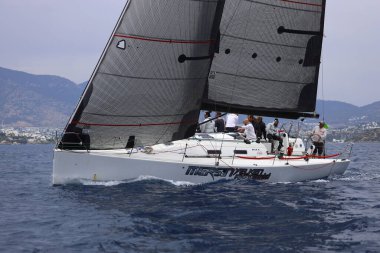 Bodrum, Hindi. 26 Mayıs 2024: Yelkenliler Ege Denizi 'nin mavi sularında, ünlü tatil beldesi Bodrum' un kıyılarında rüzgarlı havada yelken açıyorlar..