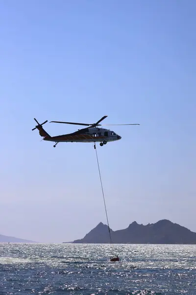 stock image Bodrum,Turkey. 16 August 2024: Firefighting helicopter takes water from the sea.