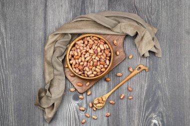 Koyu arka planda izole edilmiş ahşap kasede kırmızı fasulye..