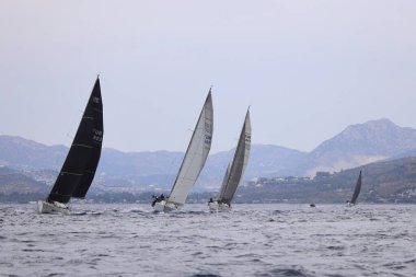 Bodrum, Hindi. 26 Mayıs 2024: Yelkenliler Ege Denizi 'nin mavi sularında, ünlü tatil beldesi Bodrum' un kıyılarında rüzgarlı havada yelken açıyorlar..