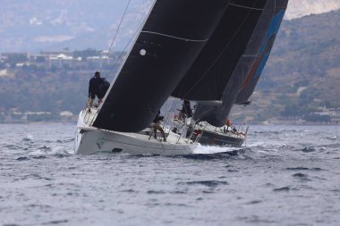 Bodrum, Hindi. 26 Mayıs 2024: Yelkenliler Ege Denizi 'nin mavi sularında, ünlü tatil beldesi Bodrum' un kıyılarında rüzgarlı havada yelken açıyorlar..