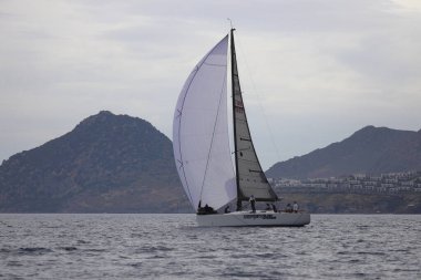 Bodrum, Hindi. 26 Mayıs 2024: Yelkenliler Ege Denizi 'nin mavi sularında, ünlü tatil beldesi Bodrum' un kıyılarında rüzgarlı havada yelken açıyorlar..