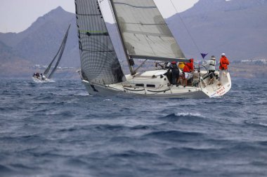 Bodrum, Hindi. 26 Mayıs 2024: Yelkenliler Ege Denizi 'nin mavi sularında, ünlü tatil beldesi Bodrum' un kıyılarında rüzgarlı havada yelken açıyorlar..