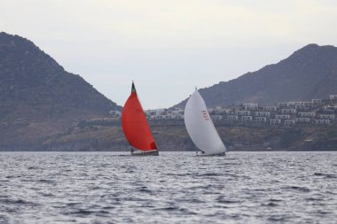 Bodrum, Hindi. 26 Mayıs 2024: Yelkenliler Ege Denizi 'nin mavi sularında, ünlü tatil beldesi Bodrum' un kıyılarında rüzgarlı havada yelken açıyorlar..