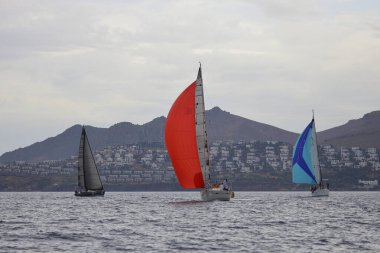 Bodrum, Hindi. 26 Mayıs 2024: Yelkenliler Ege Denizi 'nin mavi sularında, ünlü tatil beldesi Bodrum' un kıyılarında rüzgarlı havada yelken açıyorlar..