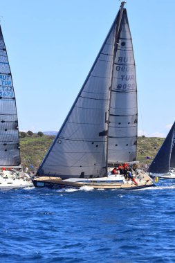 Bodrum, Hindi. 16 Mart 2024: Yelkenliler Ege Denizi 'nin mavi sularında, ünlü tatil beldesi Bodrum' un kıyılarında rüzgarlı havada yelken açıyorlar..