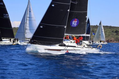 Bodrum, Hindi. 16 Mart 2024: Yelkenliler Ege Denizi 'nin mavi sularında, ünlü tatil beldesi Bodrum' un kıyılarında rüzgarlı havada yelken açıyorlar..