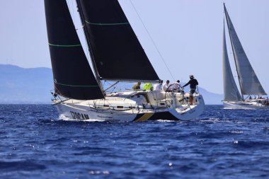 Bodrum, Hindi. 05 Ekim 2024: Ege Denizi 'nin mavi sularında, ünlü tatil beldesi Bodrum' un kıyılarında yelkenliler rüzgarlı havada yelken açıyor.